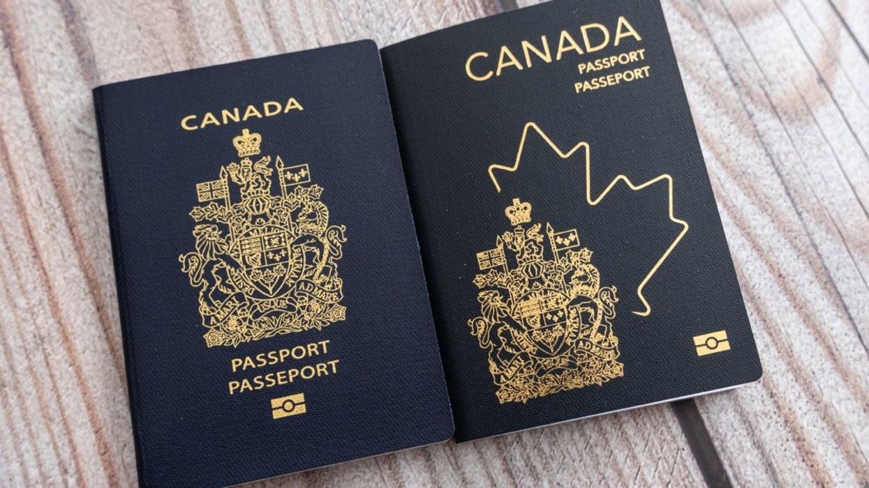 The 2013 version of the Canadian passport beside the 2023 updated version of the Canadian passport on a wooden table. 